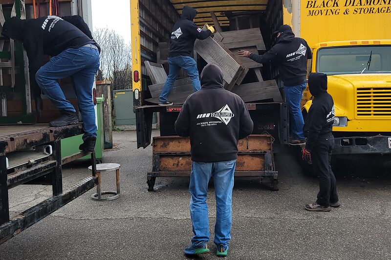 Black Diamond crew members loading scrap lumber into a truck for debris removal.